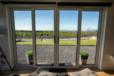 a sliding glass door with potted plants in a room at Wigtown by Wigwam Holidays in Newton Stewart