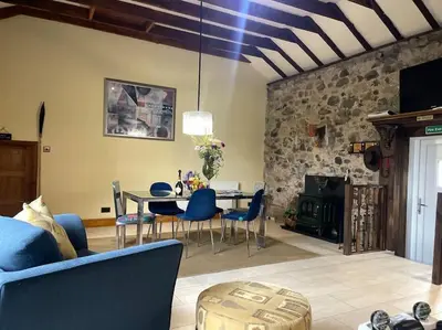 a living room with a table and blue chairs at WestLaigh Central Scotland with outdoor BBQ Hut, pets welcome in Strathaven