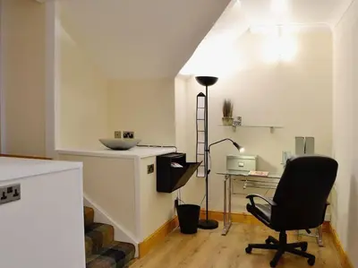 a room with a chair and a desk with a lamp at WestLaigh Central Scotland with outdoor BBQ Hut, pets welcome in Strathaven