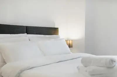 a white bed with white sheets and pillows at George St Getaway in Ayr