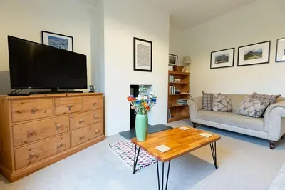 a living room with a television on a dresser at RIDGEMOUNT APT - Great base for walking and cycling in Keswick, Lake District National Park in Keswick