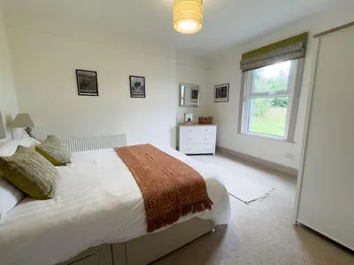 a bedroom with a large bed and a window at RIDGEMOUNT APT - Great base for walking and cycling in Keswick, Lake District National Park in Keswick