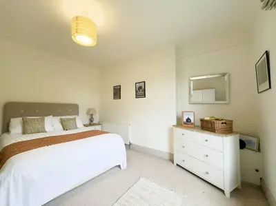 a bedroom with a bed and a dresser and a mirror at RIDGEMOUNT APT - Great base for walking and cycling in Keswick, Lake District National Park in Keswick