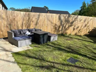 a cat sitting on a couch in a yard at Lake District Haven - Modern Comfort in Cockermouth in Cockermouth