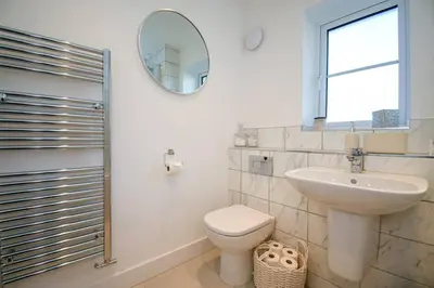 a bathroom with a toilet and a sink and a mirror at Lake District Haven - Modern Comfort in Cockermouth in Cockermouth