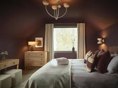 a bedroom with a large bed and a window at Eskdale Retreat in Holmrook