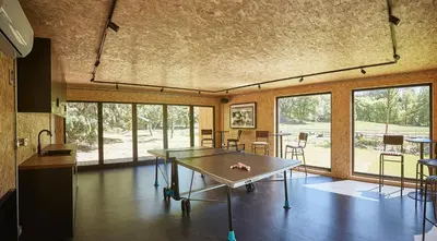 a room with a table and chairs and windows at Eskdale Retreat in Holmrook