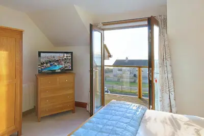 a bedroom with a bed and a sliding glass door at Inchlonaig House in Port William