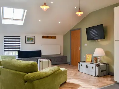 a living room with a couch and a tv at Tiberius Claudius Augustus Suite - Uk43559 in Bowness-on-Solway