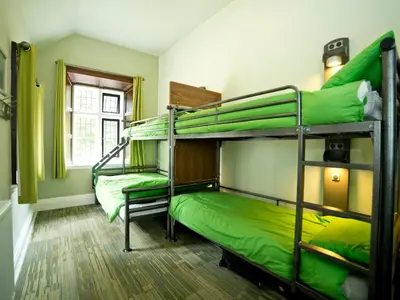 a room with two bunk beds with green sheets at YHA Wasdale Hall in Nether Wasdale
