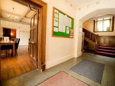 a hallway with a room with a table and a door at YHA Wasdale Hall in Nether Wasdale