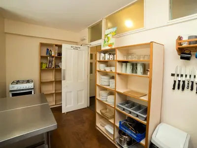 a kitchen with a counter and a pantry with shelves at YHA Wasdale Hall in Nether Wasdale