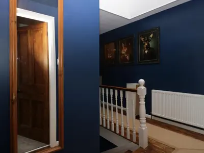 a blue room with a staircase and a door at Benstead Cottage in Seascale