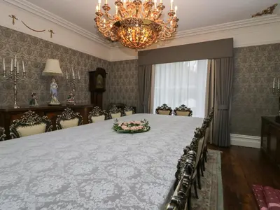 a large room with a large table with chairs and a chandelier at Beechgrove Manor in Workington