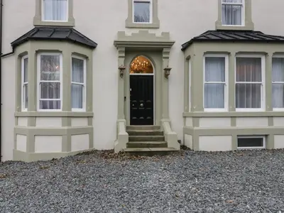 a house with two windows and a black door at Beechgrove Manor in Workington