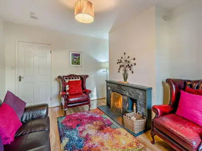 a living room with two leather chairs and a fireplace at 2 Bed in Keswick 95741 in Keswick