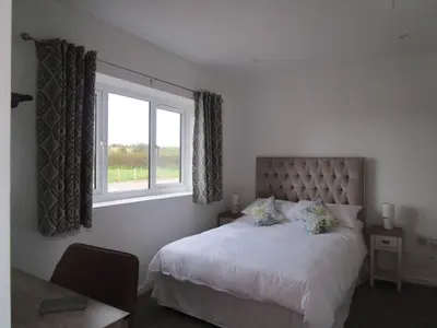 a bedroom with a large bed and a window at Oak End Stay in Carlisle