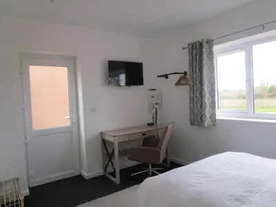 a bedroom with a desk and a bed and a window at Oak End Stay in Carlisle