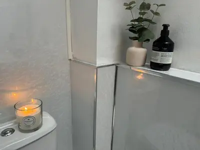 a candle and a bottle of wine on a white cabinet at Robinson's Retreat - Cockermouth - Lake District in Cockermouth