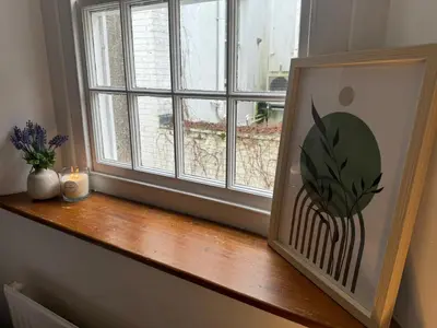 a window sill with a picture of a plant on it at Robinson's Retreat - Cockermouth - Lake District in Cockermouth