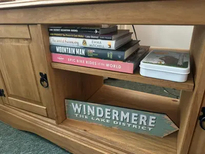 a stack of books sitting on a shelf at Robinson's Retreat - Cockermouth - Lake District in Cockermouth