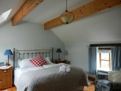 a bedroom with a large bed and a window at Armidale Cottages B&B in Workington
