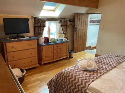 a bedroom with a bed and a flat screen tv at Armidale Cottages B&B in Workington