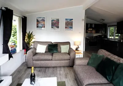 a living room with a couch and a table at Lodge by the Lake - Lake District - Hot Tub in Bassenthwaite