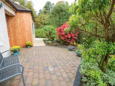 a patio with a bench in a garden at Esk Brae in Langholm