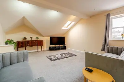 a living room with a couch and a tv at John Dalton House in Cockermouth
