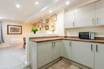 a kitchen with white cabinets and a microwave at John Dalton House in Cockermouth