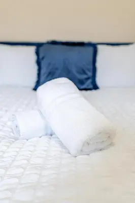 a towel laying on top of a bed at John Dalton House in Cockermouth