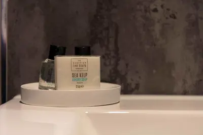 a white shelf with two bottles of soap on it at The Bradshaw in Prestwick