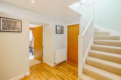 a staircase in a home with white walls and wooden floors at Balcary Tower in Castle Douglas