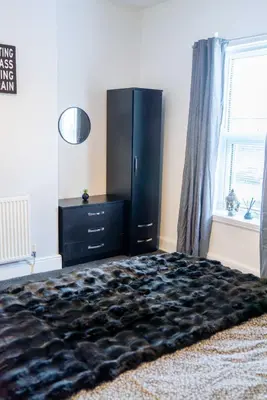 a bedroom with a black dresser and a large bed at CS House in Carlisle