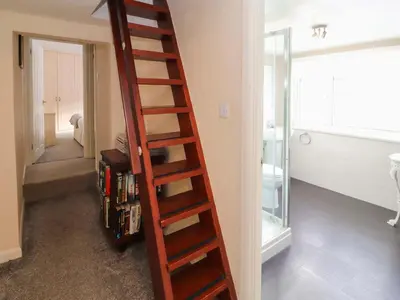 a wooden ladder in a room with a bathroom at Brews Cottage in Keswick