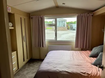 a bedroom with a large bed and a window at Ralfgus 16 Forest Views caravan Park,Moota in Plumbland