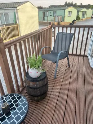 a chair and a table on a wooden deck at Ralfgus 16 Forest Views caravan Park,Moota in Plumbland