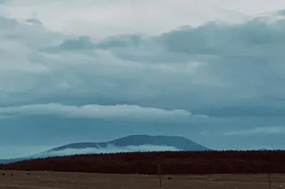 a mountain in the distance with a cloudy sky at Ralfgus 16 Forest Views caravan Park,Moota in Plumbland