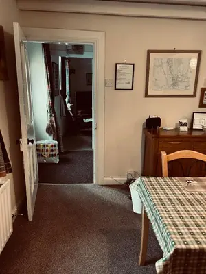 a room with a door open to a room with a table at Lazy Days in Moffat