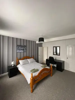 a bedroom with a large bed and a desk at Spacious Property For Hols Base & Contractors Long or Short Stays C2C Western Lakes in Cleator Moor