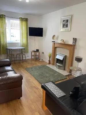 a living room with a couch and a fireplace at CosyHouse2 Private Parking Base for Lake District and Sellafield in Cleator Moor