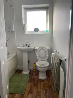 a bathroom with a toilet and a sink and a window at CosyHouse2 Private Parking Base for Lake District and Sellafield in Cleator Moor