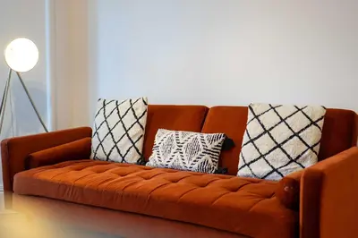 a brown couch with pillows on it in a living room at The Fairlie Suite No2 in Prestwick