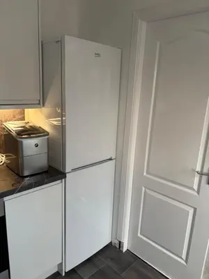 a white refrigerator in a kitchen next to a door at No 10, Ayr, 130m2, New Decor December 2024, All new entire 3 bedroom garden house in Ayr