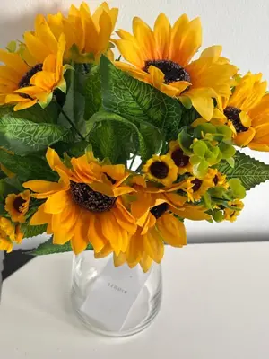 a vase filled with yellow sunflowers on a table at No 10, Ayr, 130m2, New Decor December 2024, All new entire 3 bedroom garden house in Ayr