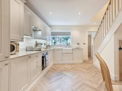 a kitchen with white cabinets and a staircase at 2 Bed in Cockermouth 95716 in Broughton Moor