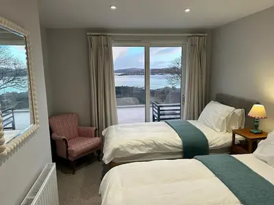 a hotel room with two beds and a window at Whitegates in Rockcliffe