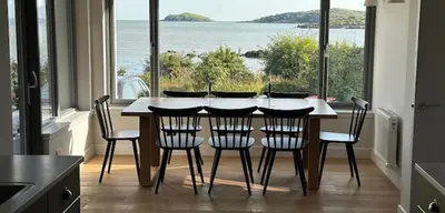 a kitchen with a table with chairs and a large window at Whitegates in Rockcliffe