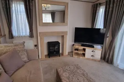 a living room with a flat screen tv and a fireplace at Ramblers Retreat in Cockermouth